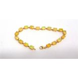 A 9 CARAT GOLD OPAL BRACELET composed of eighteen shallow oval cabochons, 18.5cm long, 7g gross