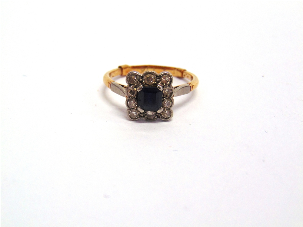 A SAPPHIRE AND DIAMOND CLUSTER RING the square cut stone enclosed by single cuts, finger size P, 2.