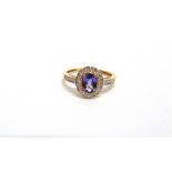 A 9 CARAT GOLD TANZANITE AND DIAMOND CLUSTER RING the oval cut enclosed by single cuts and single