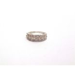 A 9 CARAT WHITE GOLD DIAMOND HALF HOOP RING the central line of seven brilliant cuts with a line
