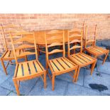 A LIGHT ELM ERCOL 'SAVILLE' EXTENDING OVAL DINING TABLE and matching set of six ladderback chairs