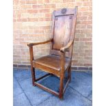 A PROVINCIAL FRUITWOOD ARMCHAIR the shaped top rail and fielded panelled back carved with