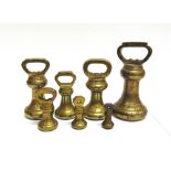 A GRADUATED GROUP OF SEVEN BRASS BELL WEIGHTS comprising 4oz, 8oz, 1lb, 2lb, 4lb (x2) and 7lb, the