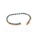 A 9 CARAT GOLD BLUE TOPAZ LINE BRACELET 18cm long, 6.9g gross