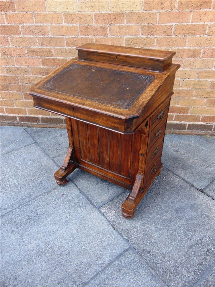 A LATE VICTORIAN OAK DAVENPORT DESK with leather inset top opening to fitted interior, four