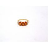 A THREE STONE FIRE OPAL GOLD RING with stone set shouldering finger size L1/2, 2g gross