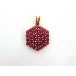 A RUBY CLUSTER 9 CARAT GOLD PENDANT of hexagonal outline, 3g gross