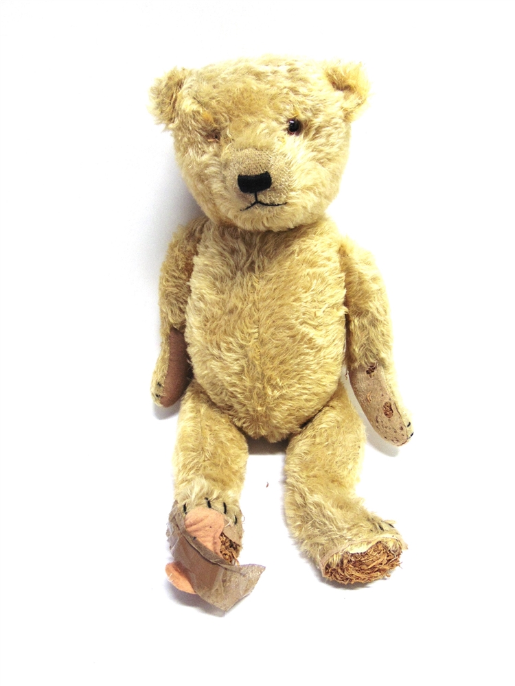 AN ENGLISH PALE GOLD MOHAIR TEDDY BEAR with orange glass eyes (one lacking) and a black vertically