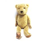 AN ENGLISH PALE GOLD MOHAIR TEDDY BEAR with orange glass eyes (one lacking) and a black vertically