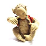 A FARNELL ALPHA TOYS MUSICAL SEATED MONKEY SOFT TOY with a felted cloth face and ears, inset side-