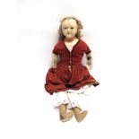 A POURED WAX SHOULDER HEAD DOLL with a blonde ringlet wig, inset blue glass eyes and a painted