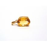 AN OVAL CITRINE PENDANT stamped '10k', measuring 17.6 by 12.7 by 8.4mm deep, 5.2g gross