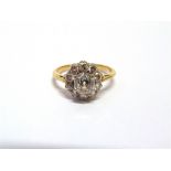 AN ELEVEN STONE DIAMOND CLUSTER RING unmarked mount, the central old brilliant cut of