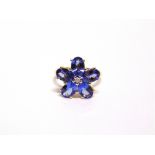 A 9 CARAT GOLD FIVE STONE TANZANITE RING of flower head design with a small brilliant cut diamond to