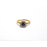 A SAPPHIRE AND DIAMOND RING the round cut stone enclosed by single cuts, 2.7g gross