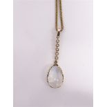A MOONSTONE AND SEED PEARL DROP PENDANT ON A CHAIN the tear shaped cabochon with a suspension of