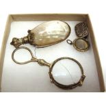 A GILT METAL SHELL MOUNTED SCENT BOTTLE a gilt metal lorgnette; a mourning brooch; and a gilt