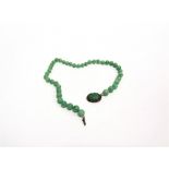 A JADE BEAD NECKLACE the forty one graduated beads of approximately 9-5mm diameter, to a filigree