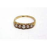 A FIVE STONE SPLIT PEARL RING stamped '18ct', the graduated pearls (untested and unwarranted) with