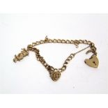 A 9 CARAT GOLD BRACELET of curb links, with two charms attached, 12.3g gross