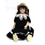 A LARGE BISQUE SOCKET HEAD DOLL with a replacement long brown wig, fixed brown paperweight eyes,