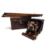 A SANDERSON MAHOGANY & LACQUERED BRASS FOLDING BELLOWS CAMERA with a black leather body, in a