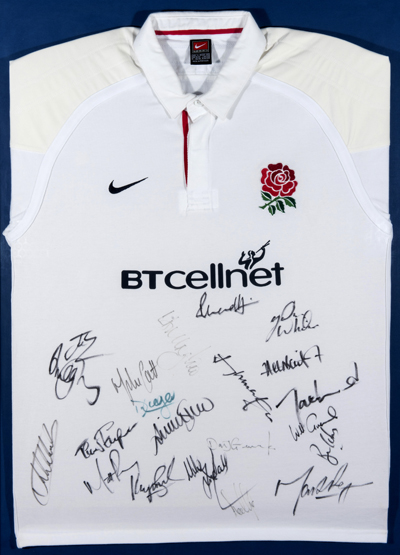 A framed England rugby shirt signed by the touring team to South Africa in 2000,