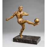 Spelter figure of a footballer, gilt-bronze patina, modelled striking a right-foot volley,