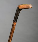 A golf club walking stick, modelled as a socket-head wooden putter with lead insert to rear,