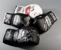 A group of four signed boxing gloves, bearing a total of 14 autographs on a pair of black Everlast,