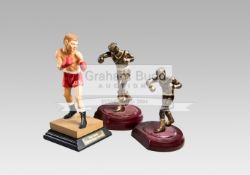 Three boxing figurines, two similar metalware figures of amateur boxers,