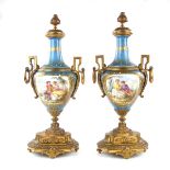 A pair of French ormolu mounted porcelain twin handled urns modelled in the Sevres style,