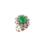 White gold emerald and diamond flower ring. The oval cut emerald weighing approx. 1.