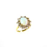 18 ct yellow gold opal and diamond cluster ring. The oval opal cabochon weighing approx. 1.