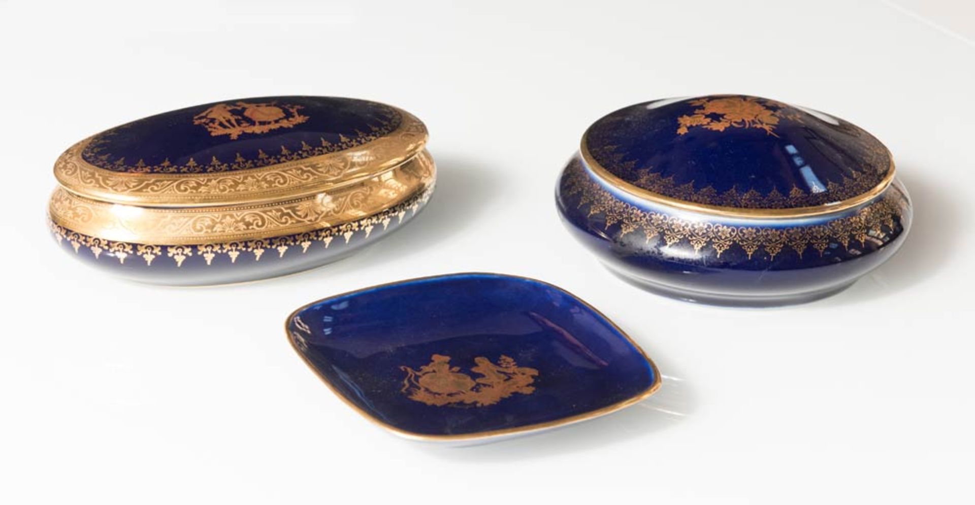 Limoges, tre oggetti in porcellana blu con profili e decorazioni in oro, Francia, XX sec.