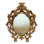 An Italian giltwood wall mirror carved in high relief with scrolling rococo foliage, 47cm wide x