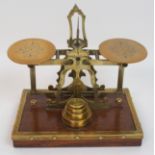 A set of Victorian postal scales of typical form with foliate engraved details, raised on a mahogany