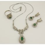 An emerald and diamond suite comprising of a necklace, earrings and a ring, the necklace features