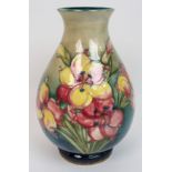 A Moorcroft pottery freesia vase tubelined with stylised flowers on a shaded blue green ground, blue