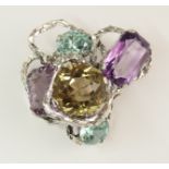 A statement brooch the white metal free form textured loops are set with fancy cut amethysts, blue