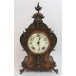 A late 19th century / early 20th century walnut mantle clock with ormolu cherub mounts and urn