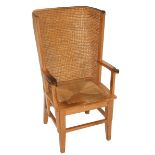 An oak Orkney armchair the curved straw-work back joined to scroll arms above a straw woven drop-