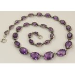 A silver amethyst necklace set with graduated facet cut amethysts from largest 14mm x 11 to smallest