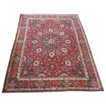 A red ground meshed rug with a blue central medallion and border, 370 x 294cm