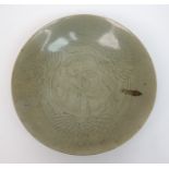 A Chinese celadon saucer dish incised with a cray fish and foliage (cracked), 33.5cm diameter