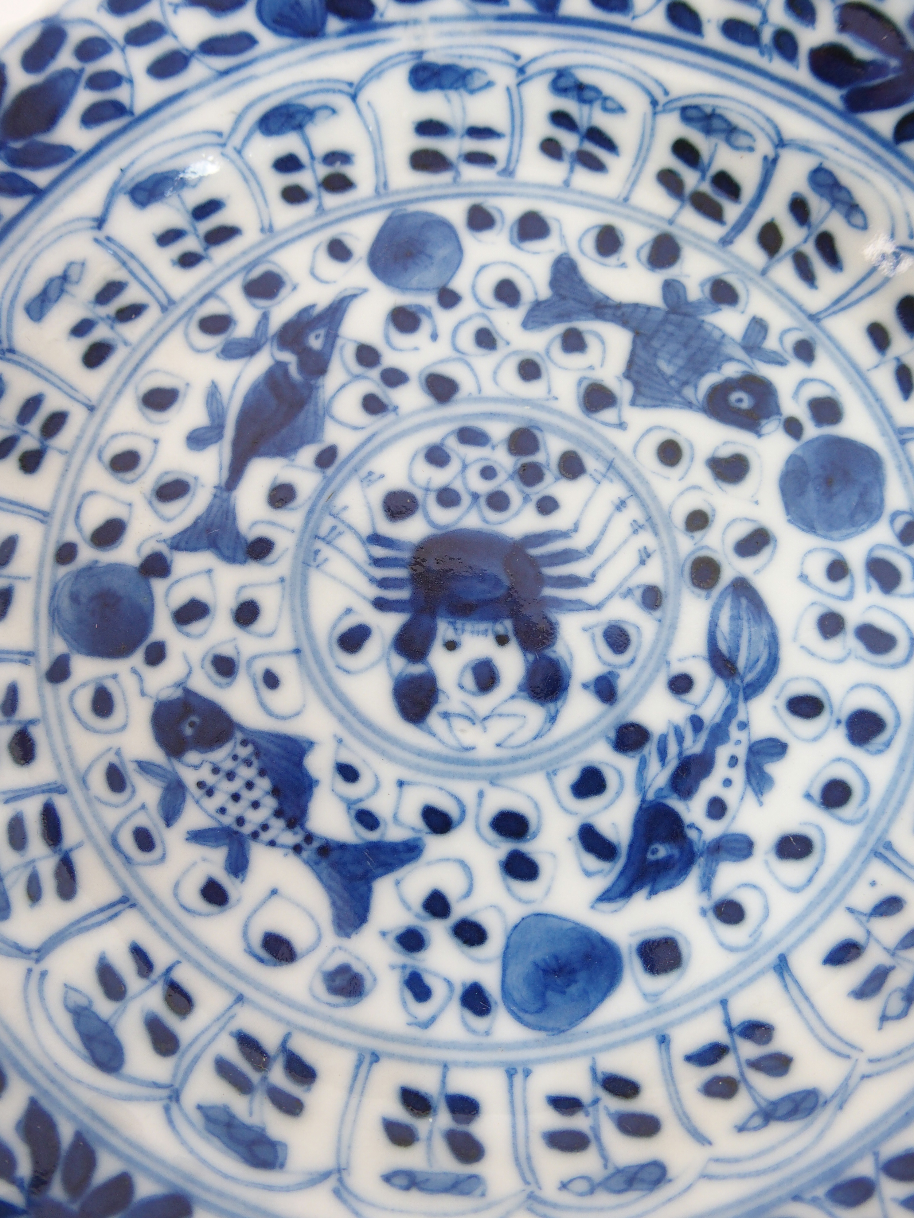 A Chinese blue and white tea bowl and saucer painted with fish surrounding a crab amongst foliage, - Bild 4 aus 10