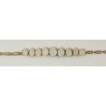 A graduated white opal bracelet with a decorative link yellow metal bracelet with box clasp to the