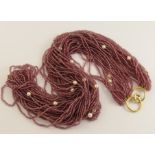 A garnet and pearl festoon necklace with a 14ct gold clasp twenty strands of fine garnet beads are