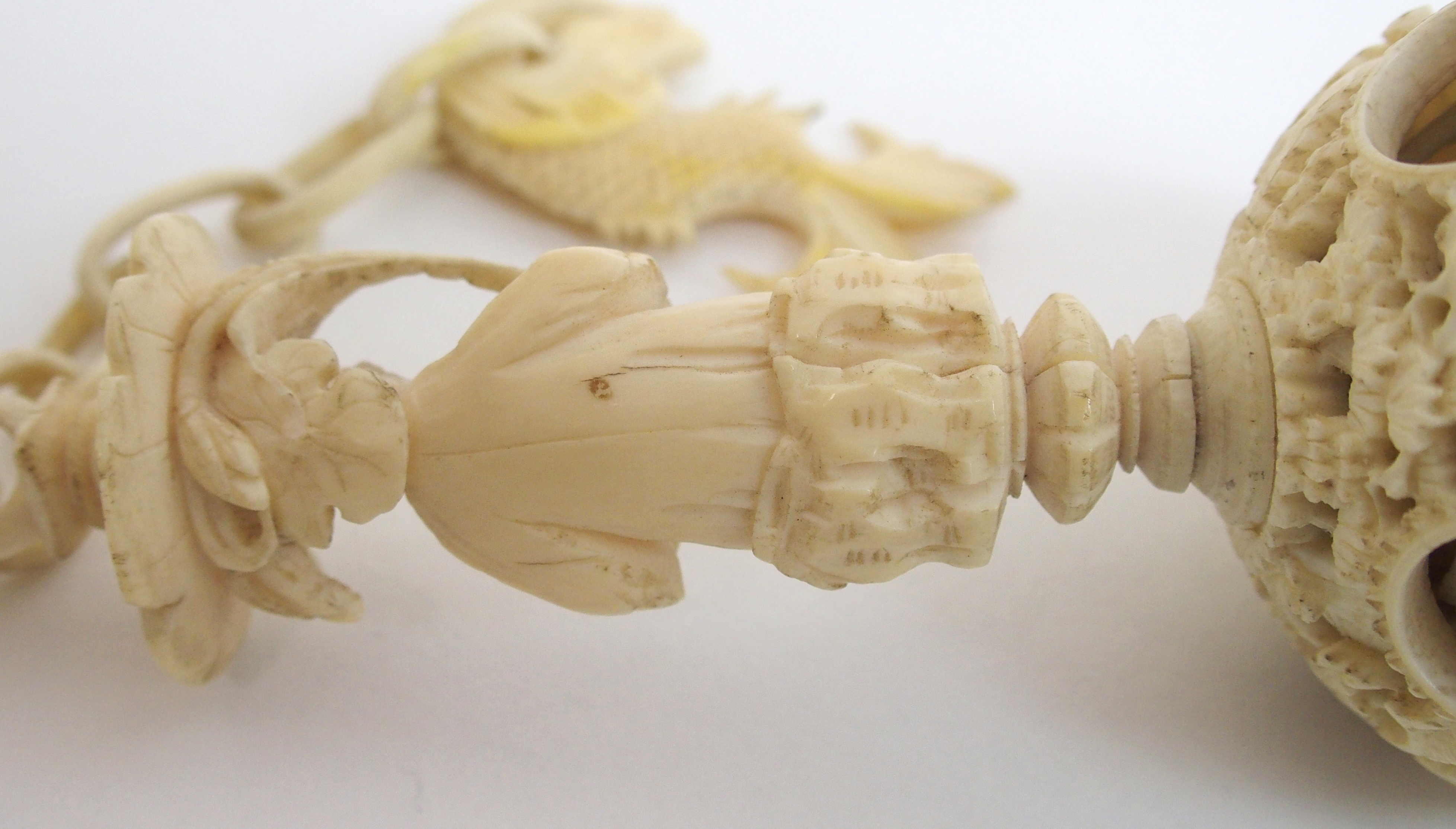 A Cantonese ivory concentric ball carved with dolphin and chain suspension attached to a figure - Bild 6 aus 10