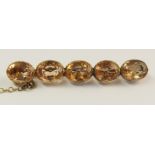 A yellow metal topaz brooch the topaz are of an apricot colour they have been assessed for insurance